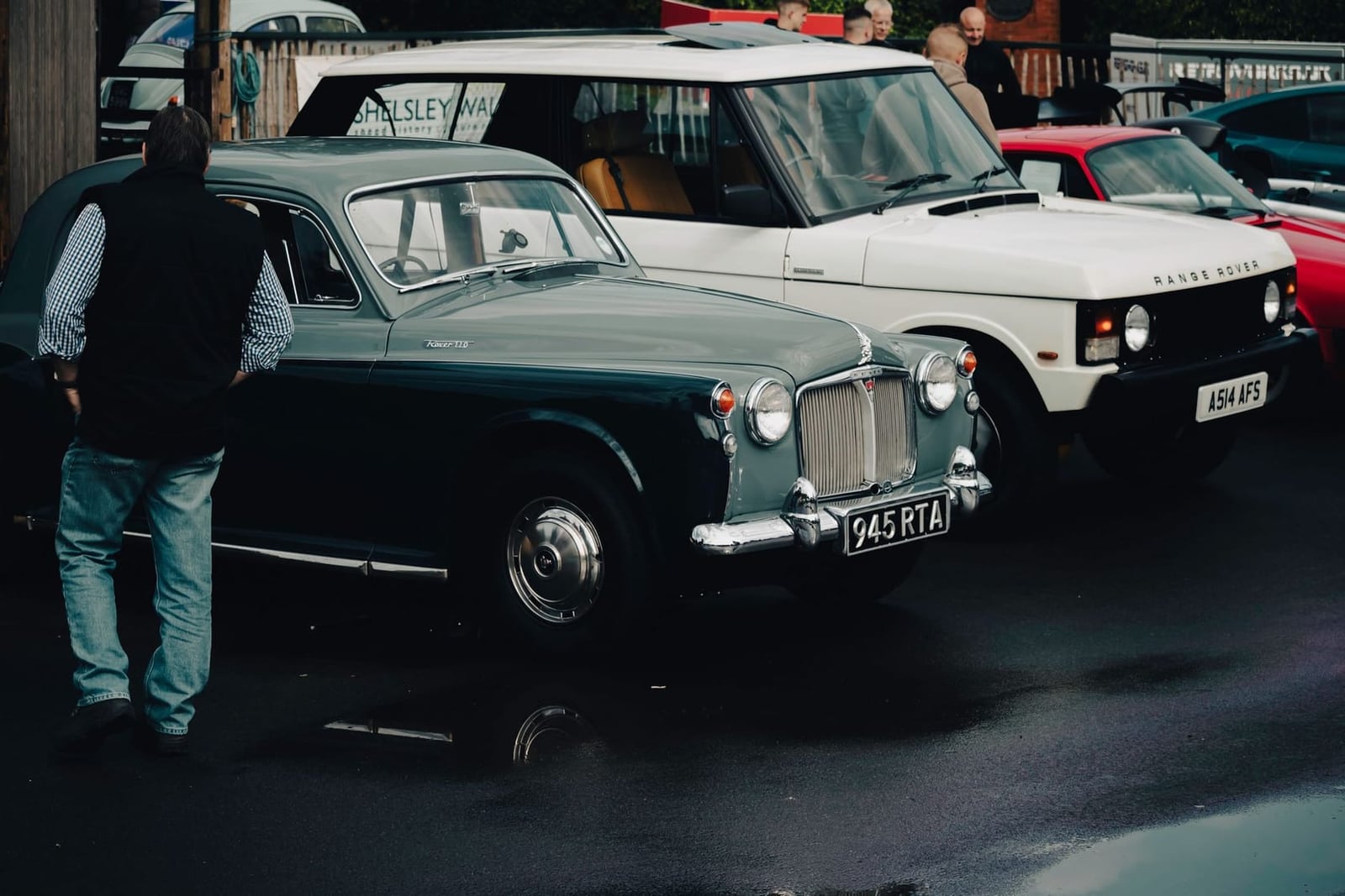 A dark Rover P5 saloon at a classic car gathering among other vehicles