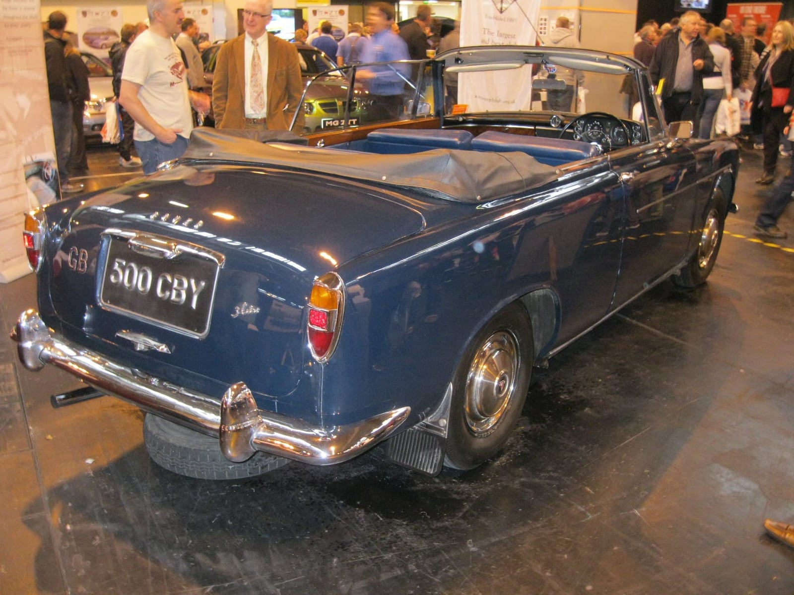 The rear of a dark blue Rover P5 convertible conversion by Panelcraft at an indoor show, UK registration 500 CBY