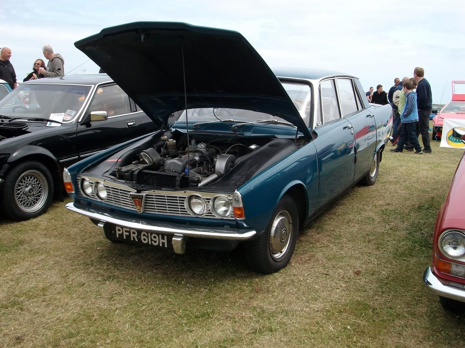 A blue 1970 Rover P6 2000 Series 1 with its bonnet raised at a classic car show, UK registration PFR 619H