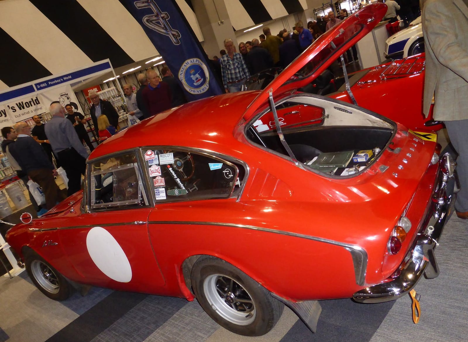 A red Sunbeam Harrington Le Mans in racing trim displayed indoors with its bonnet raised