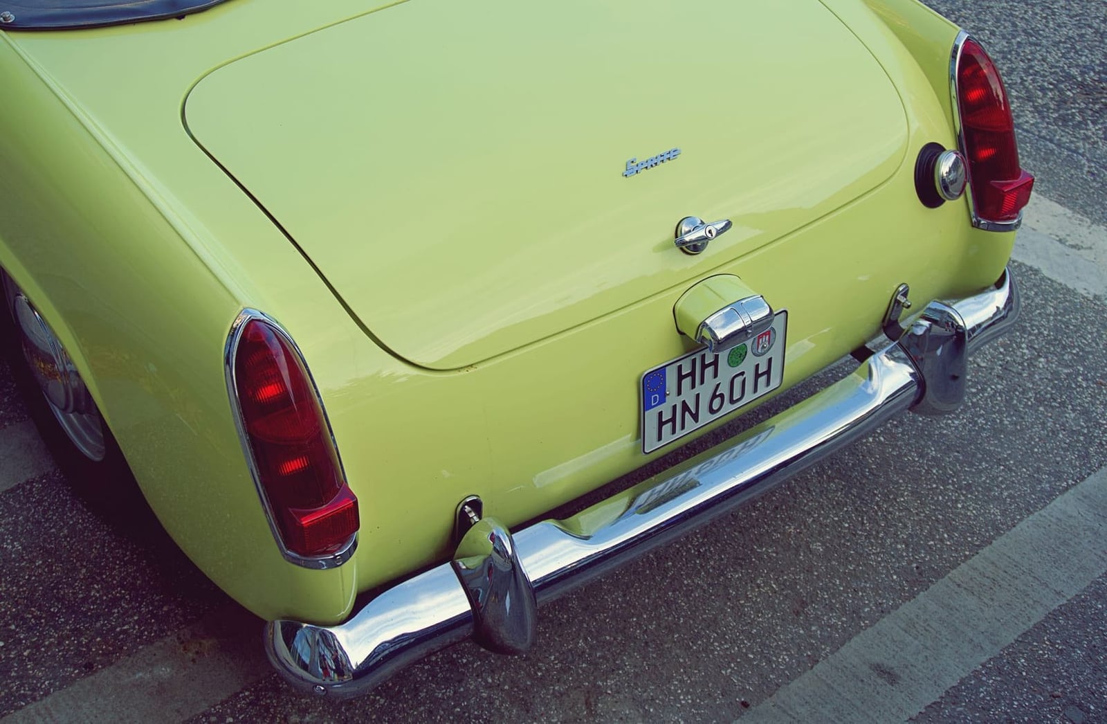 Close-up of the rear lamp and boot script of a lime green Sunbeam Alpine