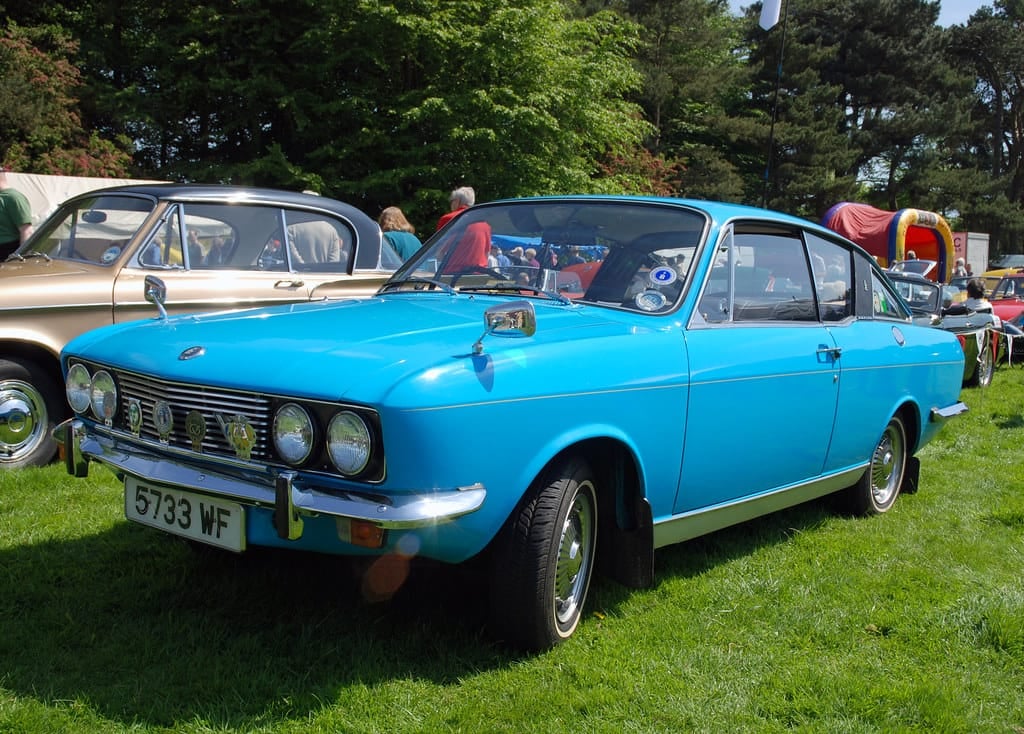 A blue Sunbeam Rapier fastback on grass at a classic car show, front three-quarter view, UK registration 6733 WF