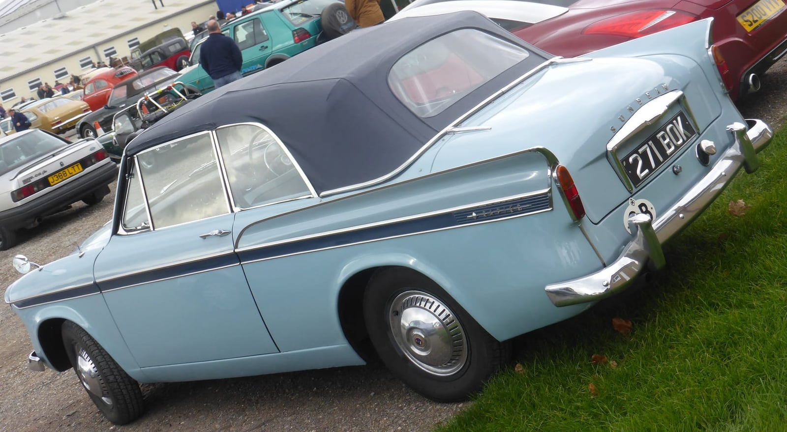 A pale blue 1960 Sunbeam Rapier Series III convertible with its dark hood raised, rear three-quarter view, UK registration 271 BOY