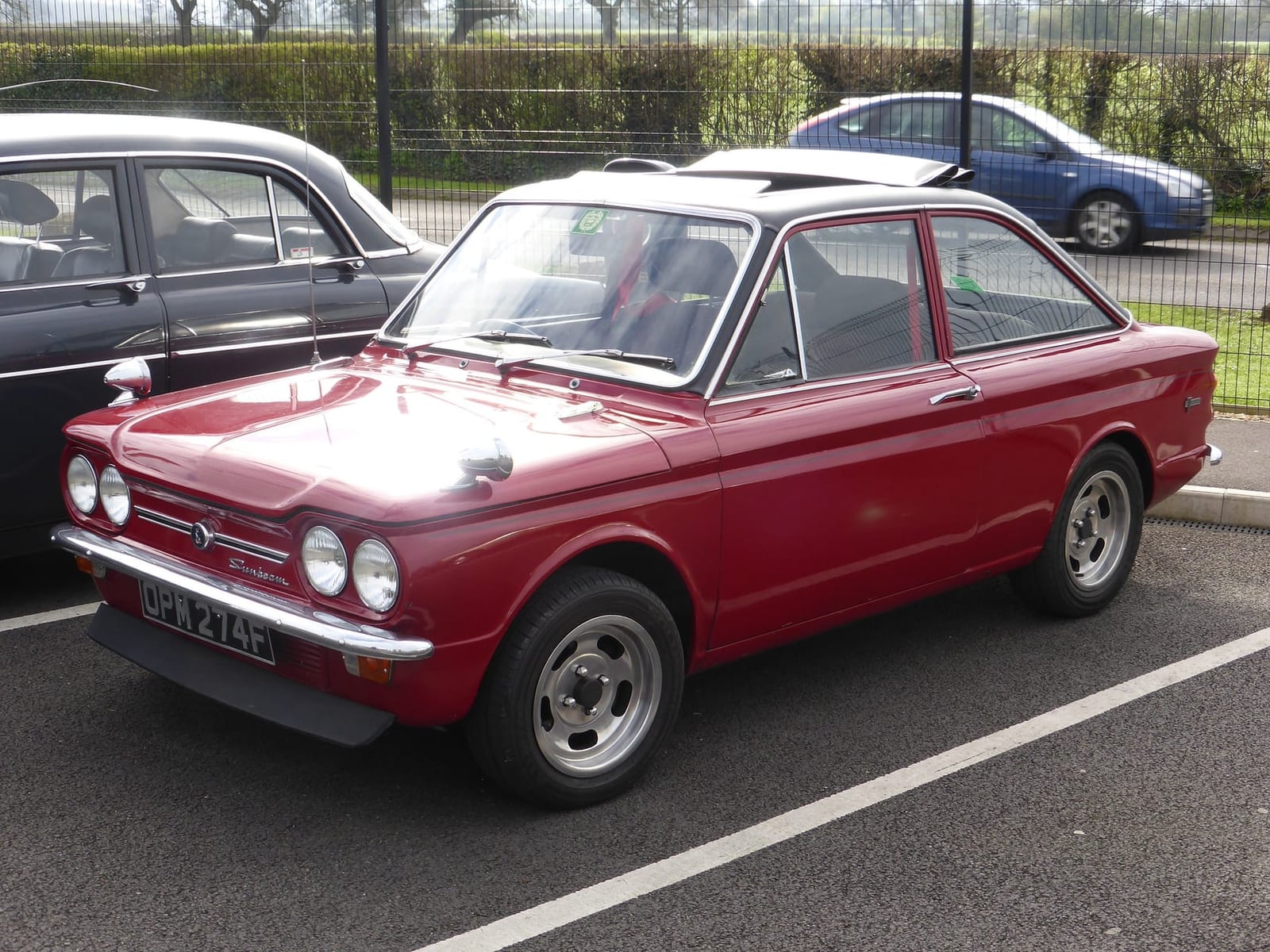 A red Sunbeam Stiletto with black vinyl roof, front three-quarter view, UK registration OPM 274F