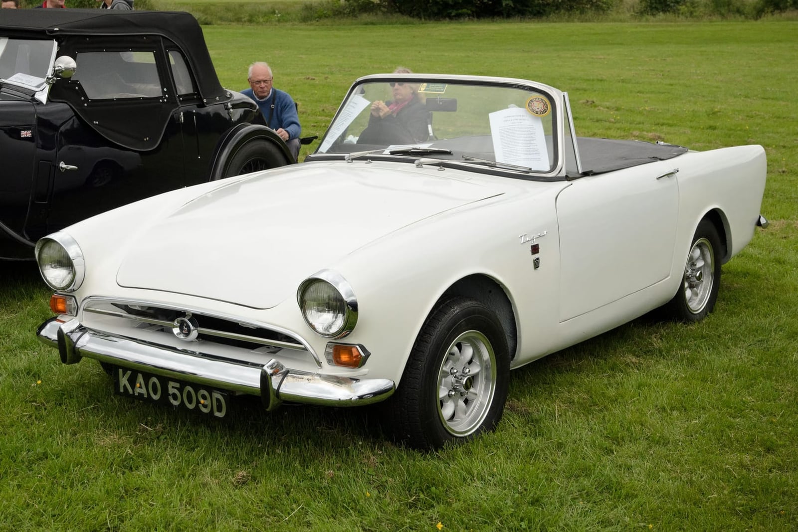 A white 1965 Sunbeam Tiger Mk I on grass, front three-quarter view, UK registration KAO 509D