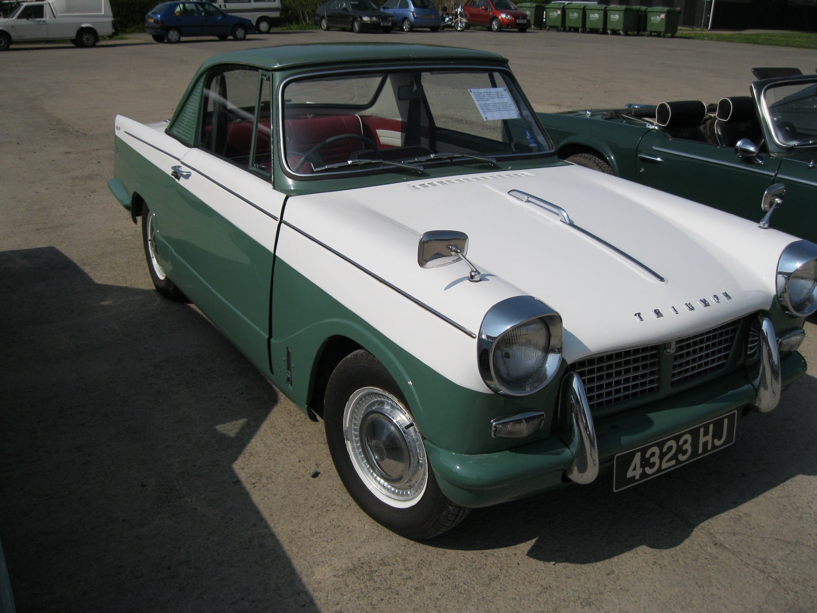 A green and white two-tone Triumph Herald coupe, front three-quarter view
