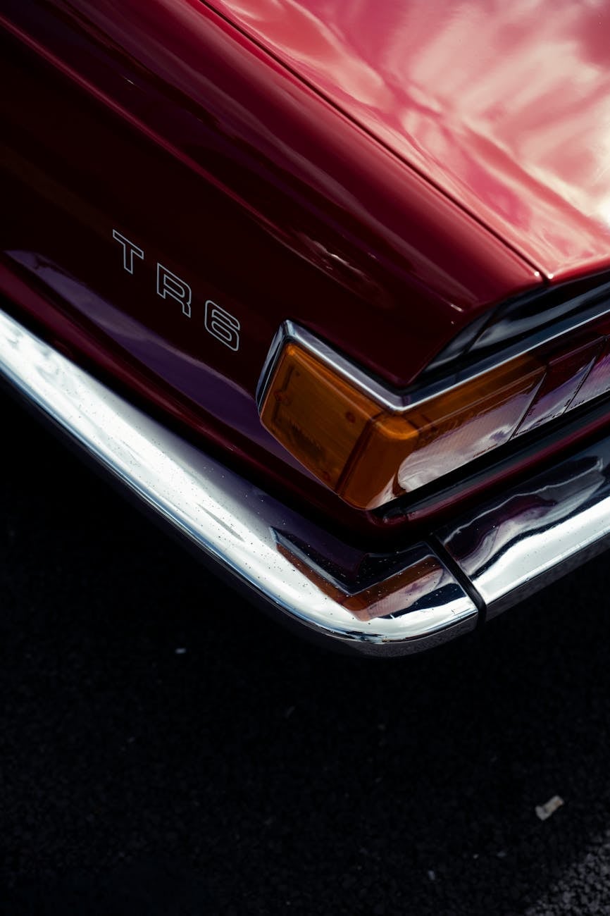 Close-up of the embossed TR6 script and amber indicator on the rear corner of a red Triumph TR6