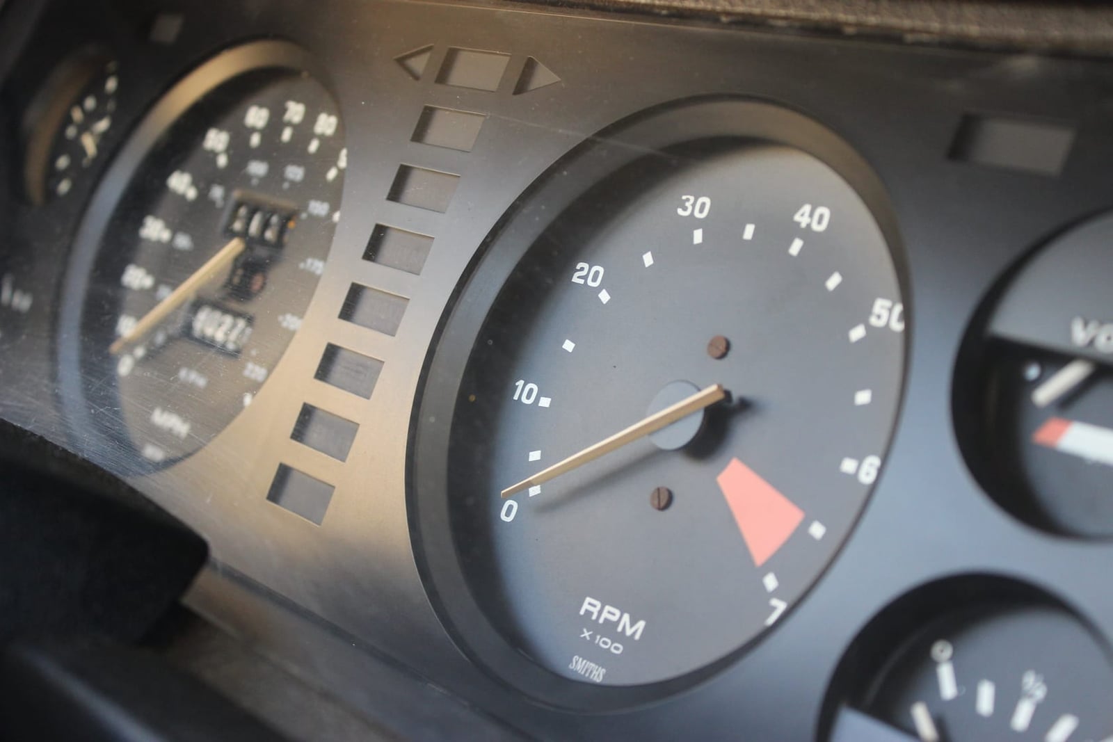 Close-up of a Triumph TR7 instrument binnacle showing the rev counter and speedometer