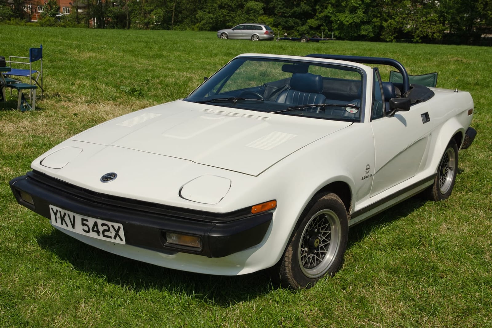 A white 1982 Triumph TR8 convertible on grass, front three-quarter view, UK registration YKV 542X