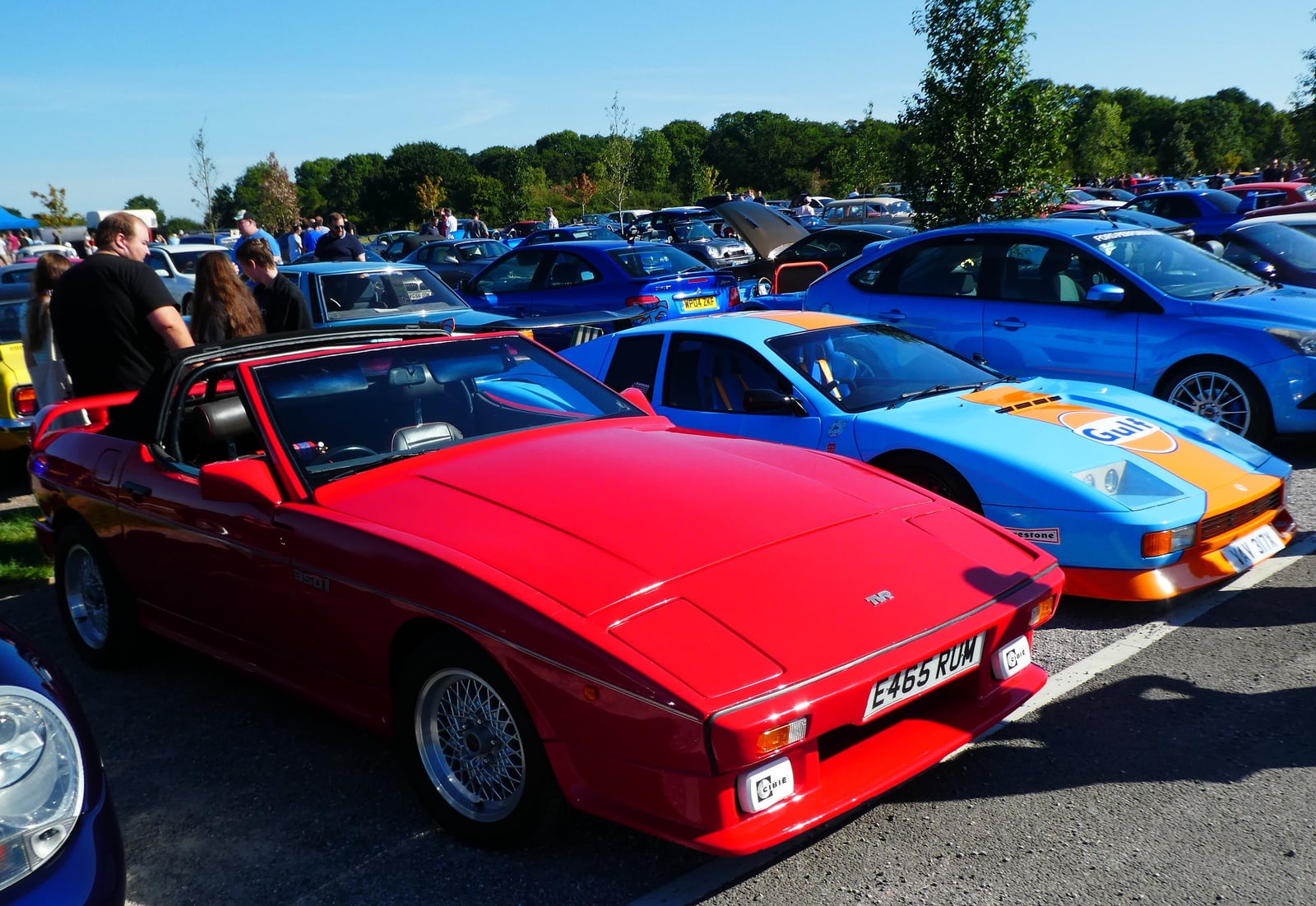 A red TVR 350i convertible, front three-quarter view at an outdoor classic car gathering