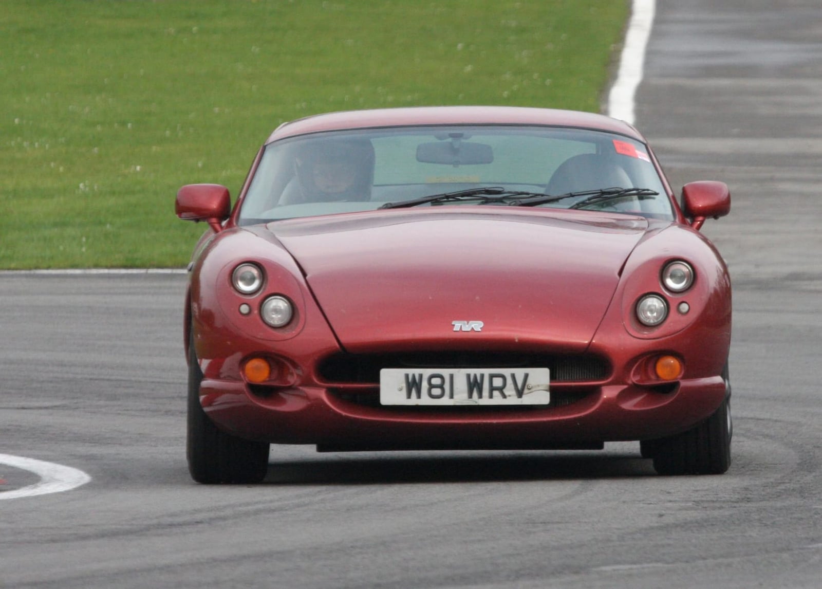 A dark red TVR Cerbera on a race circuit, front three-quarter view, UK registration W81 WRV