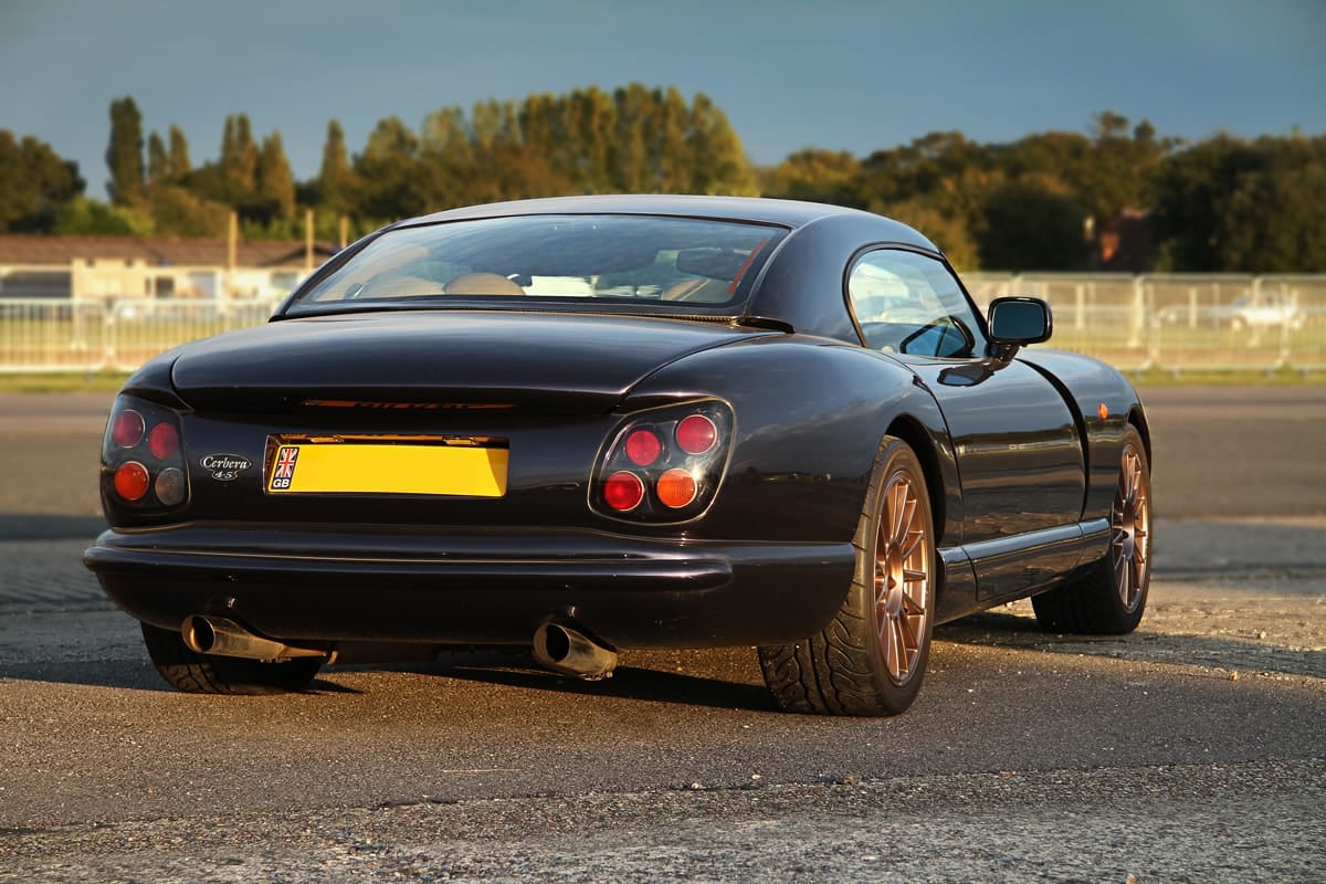 The rear of a black TVR Cerbera at an airfield in evening light