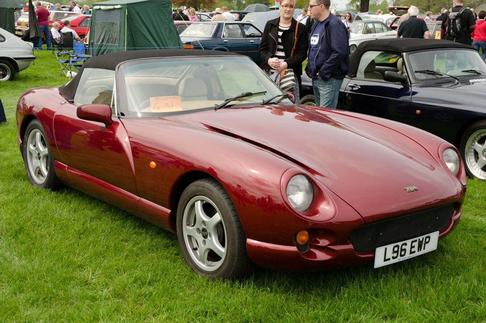 A dark red TVR Chimaera roadster, front three-quarter view on grass at a show