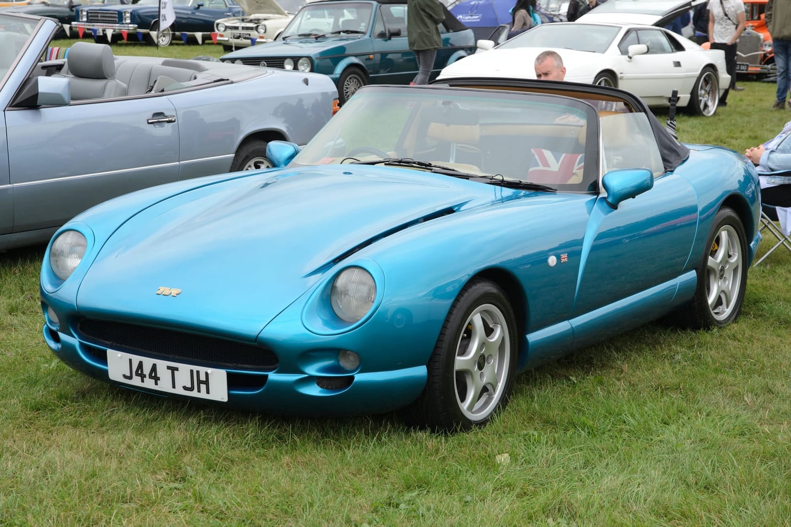 A bright blue 1999 TVR Chimaera 4.0 with UK registration J44 TJH on a show field