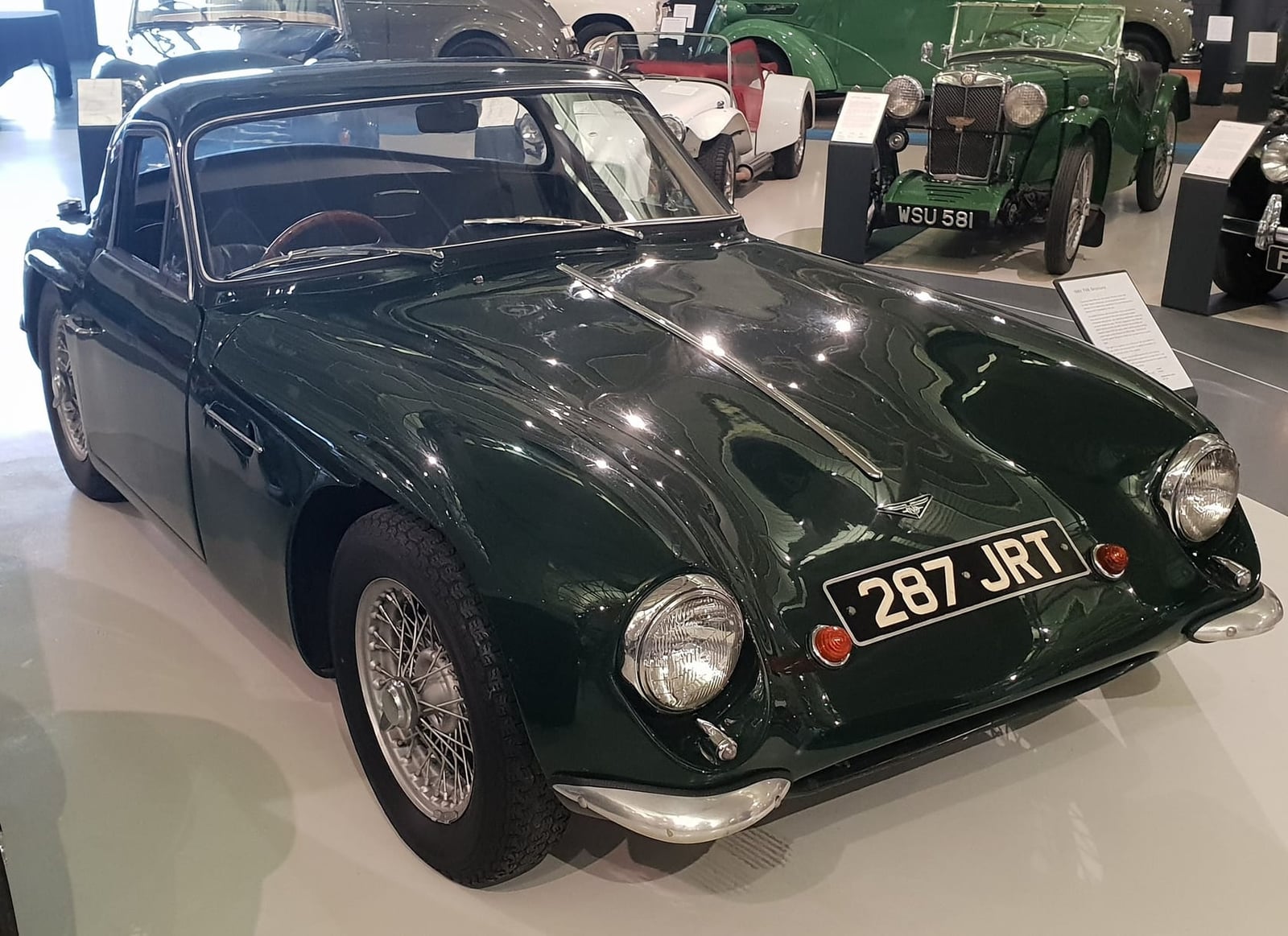 A dark green 1961 TVR Grantura with UK registration 287 JRT displayed in a museum