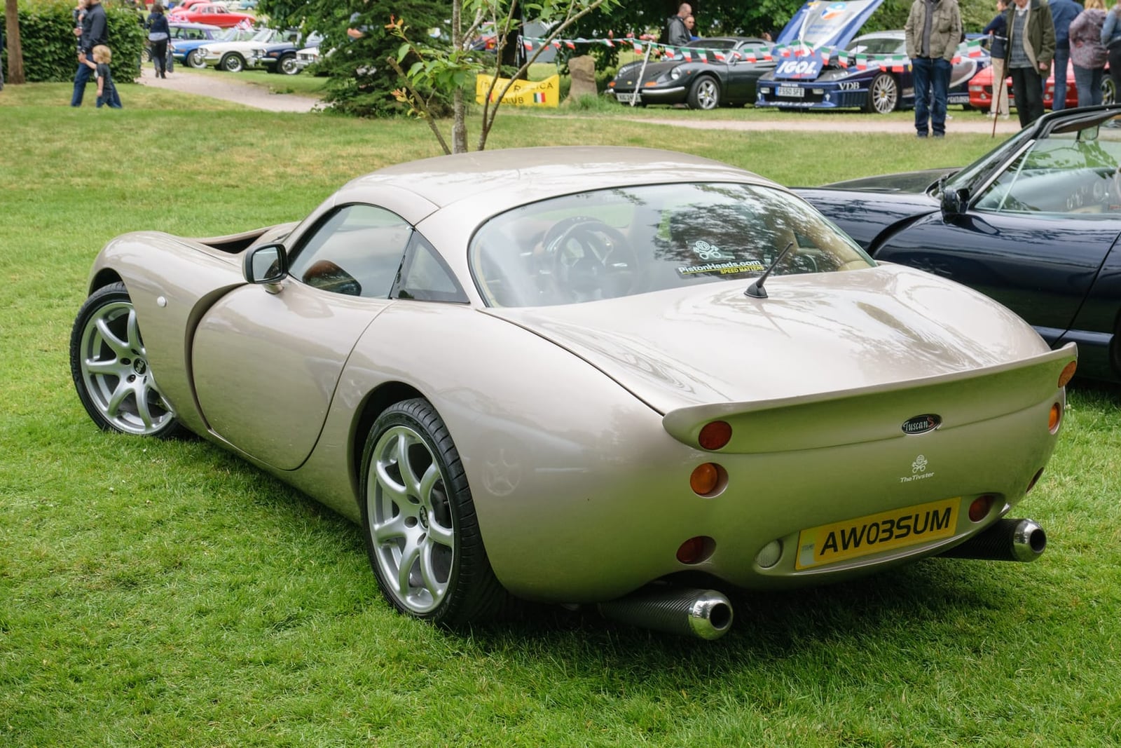 The rear view of a champagne 2003 TVR Tuscan S showing the stacked tail lights