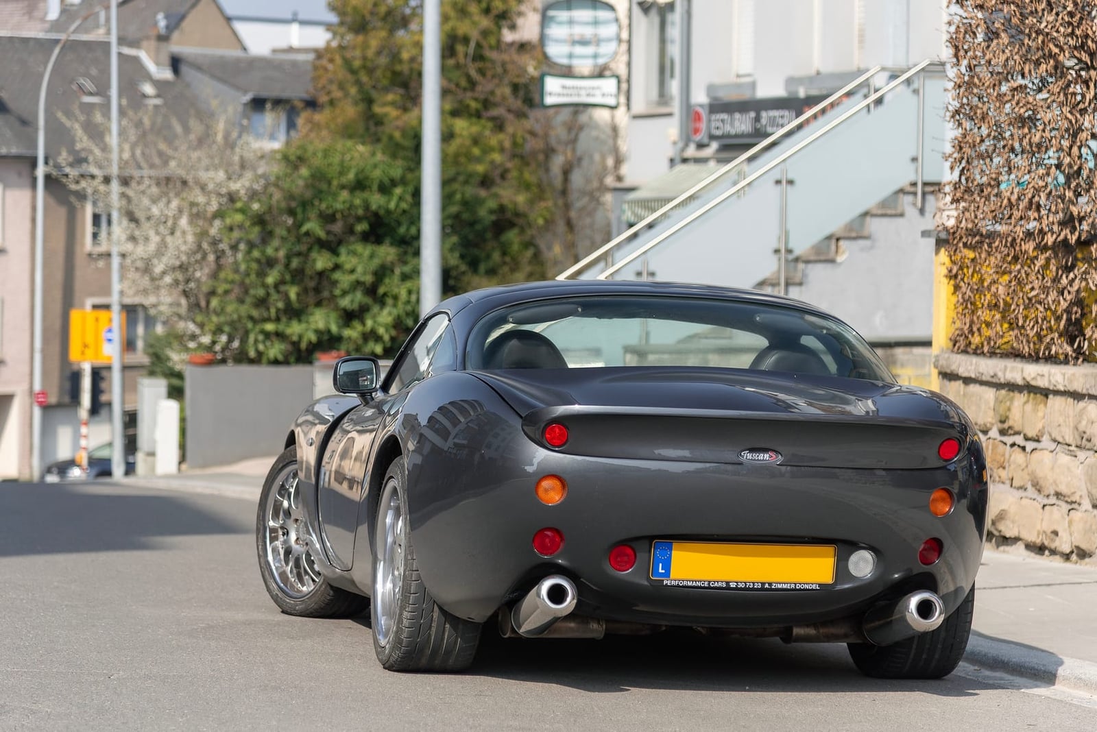 The rear of a grey TVR Tuscan on a residential street