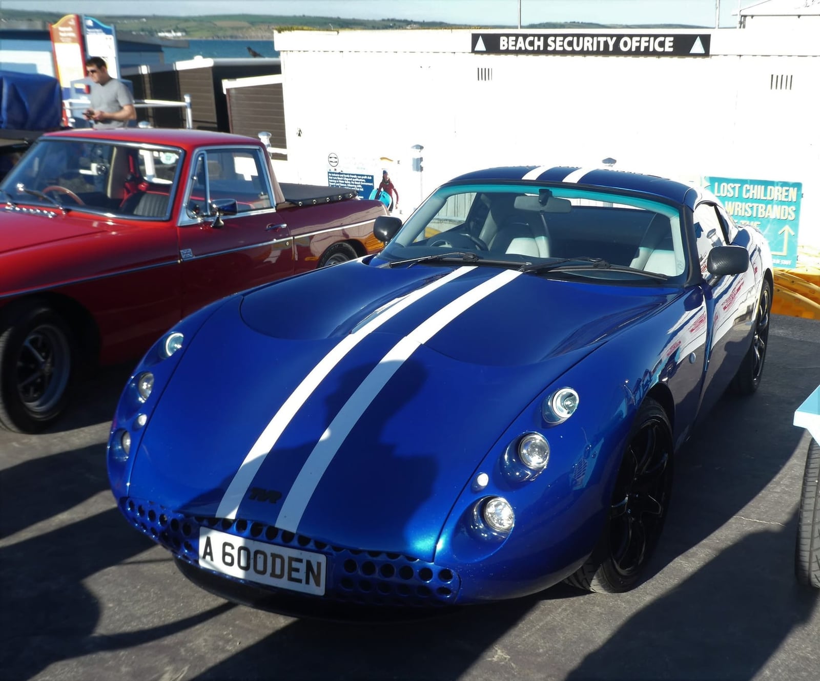 A blue TVR Tuscan S with white stripes parked at a seafront show