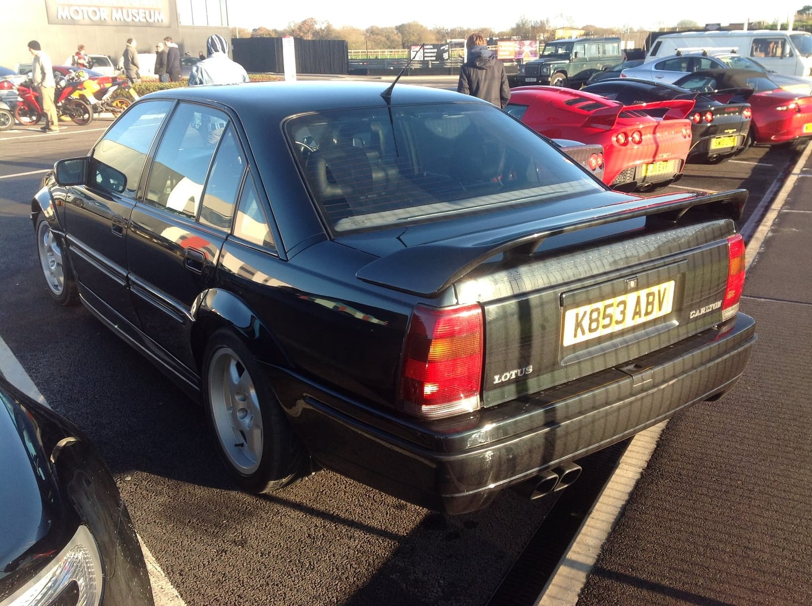 The rear three-quarter of a dark green Lotus Carlton saloon with boot spoiler, UK registration K853 ABV