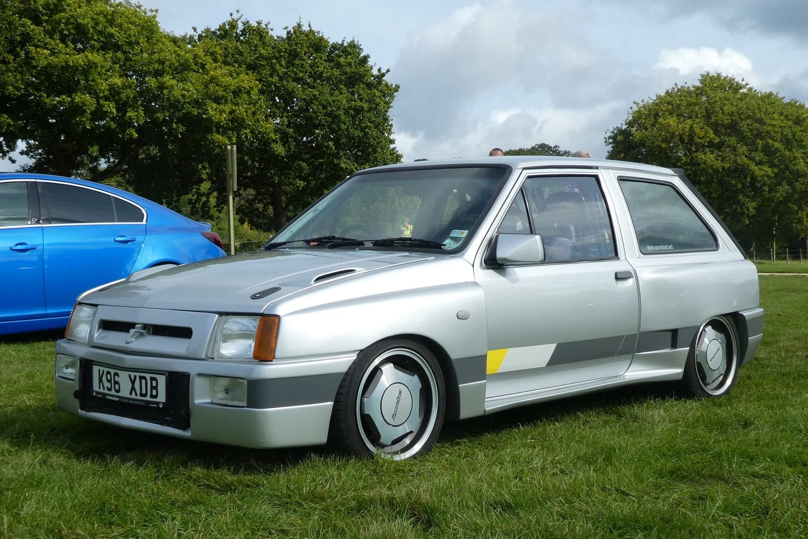 A silver Vauxhall Nova Corsa Sprint with rally bodykit on a show field