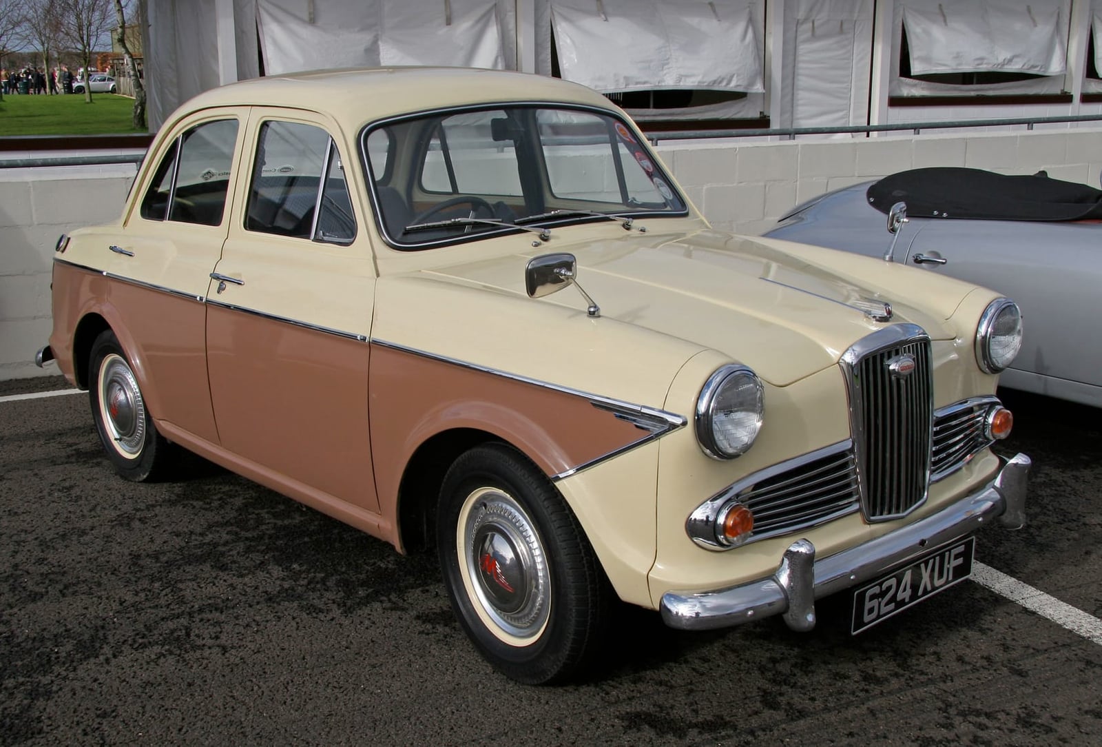 A cream and brown two-tone Wolseley 1500 saloon parked on tarmac, front three-quarter view, UK registration 624 XUF