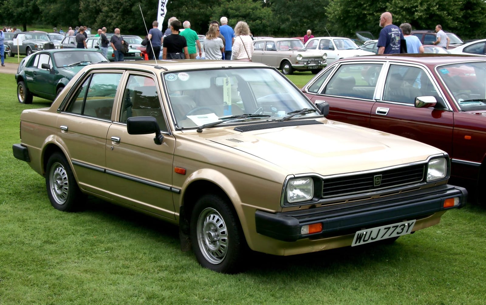 A gold 1983 Triumph Acclaim HLS Triomatic at a classic car show, front three-quarter view, UK registration WUJ 773Y